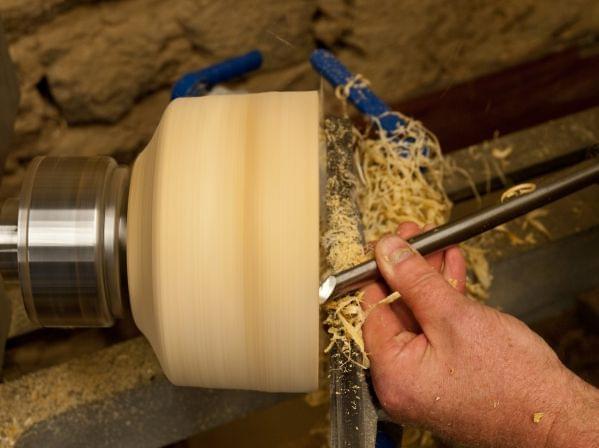 a person turning a woodturned bowl