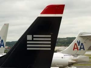 A US Airways plane rests near two American Airlines jets at Ronald Reagan Washington National Airport last year. The combined carrier would be named American Airlines.