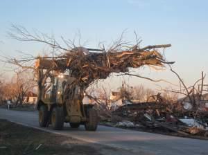 A clean up truck hauls away broken tree branches in Gifford, Ill. on Nov. 18, 2013.