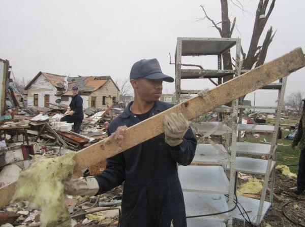 Chelorenz Watts, 19, helps clear debris from a home destroyed by the storm in Gifford, Ill.