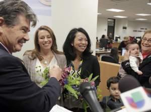 Cook County Clerk David Orr, left, performs a marriage ceremony for Theresa Volpe, second from left, and Mercedes Santos on Friday, Feb. 21, 2014, in Chicago.