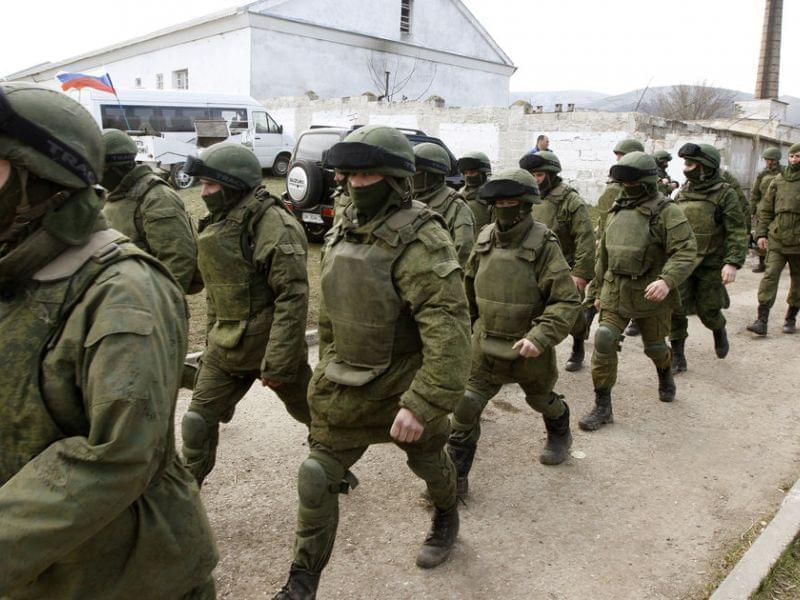 Armed men, believed to be Russian troops, walk outside a Ukrainian military base in Perevalnoye, near the Crimean city of Simferopol, on Friday.