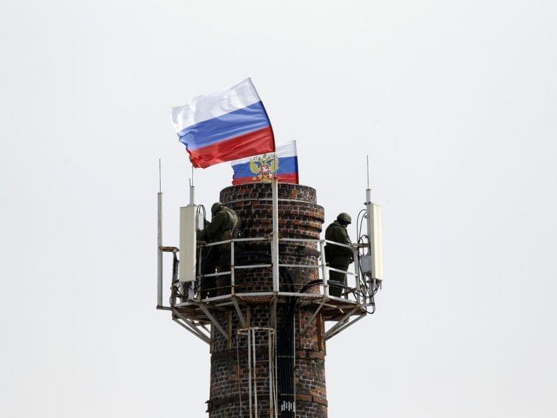 Armed men stood atop a chimney near Ukraine's naval headquarters in Sevastopol, Crimea, on Wednesday. They raised Russian flags after taking over much of the facility.