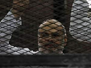 Egyptian supporters of the Muslim Brotherhood are seen during their trial in the killing of a police officer last year.