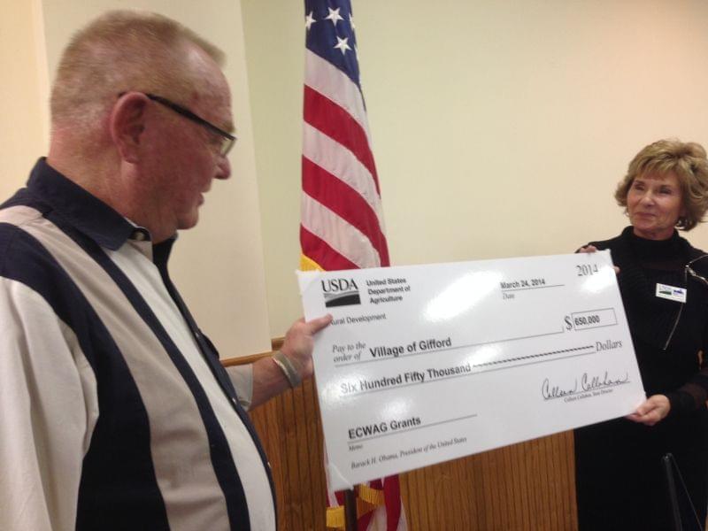 The USDA's Colleen Callahan present Gifford Mayor Derald Ackerman with a check to made needed improvements to the town's water plant and tower.