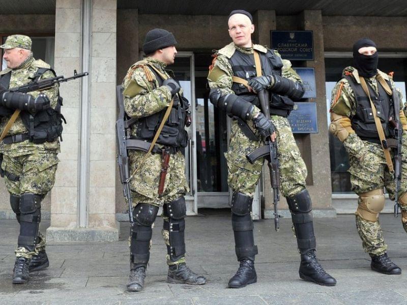 Armed men in military fatigues stood guard Monday outside a regional administration building they seized in the eastern Ukrainian city of Slovyansk.