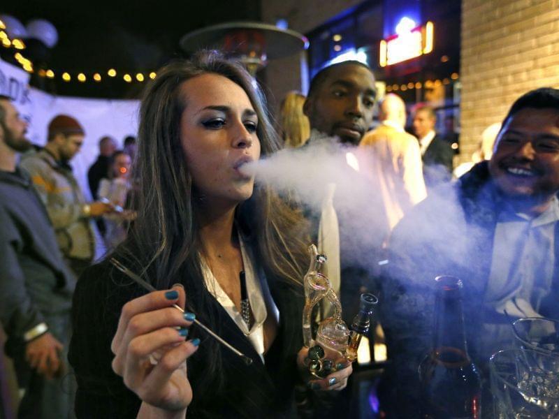 In this Dec. 31, 2013, file photo, partygoers smoke marijuana during a Prohibition-era themed New Year's Eve party at a bar in Denver, celebrating the start of retail pot sales.
