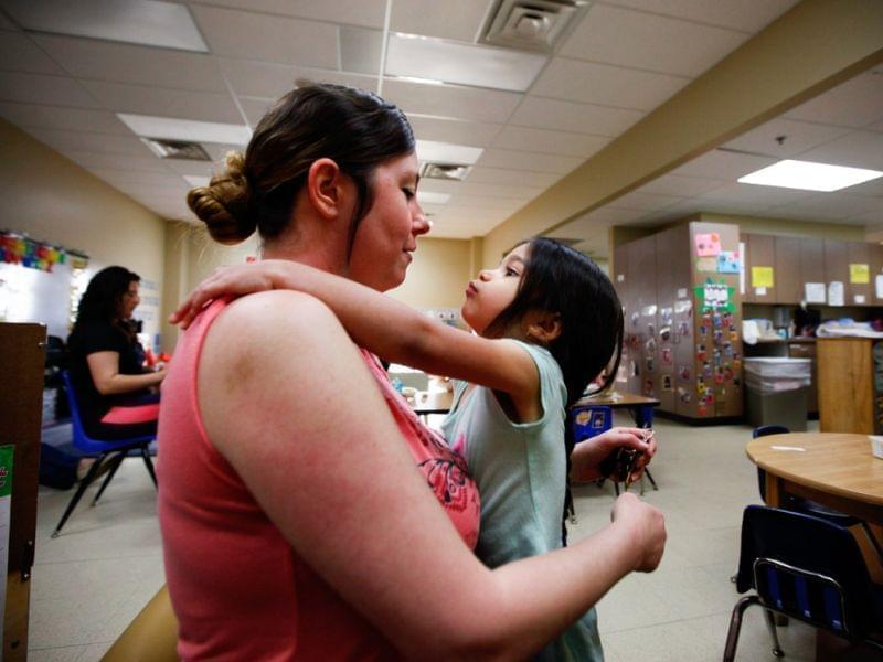 Tiffany Contreras kisses her daughter Kyndall, 4, goodbye at Disney Elementary in Tulsa, Okla. As part of a pilot program that aims to educate both children and families, Contreras takes classes at Tulsa Community College for free.