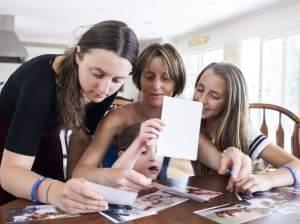 Melissa Sherak Glasser (center) looks at family photos with daughters Gabriella, 14, Lily, 5, and Maya, 11, at home in Woodland Hills, Calif.