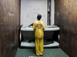 A male juvenile stands in a room at Harrison County Juvenile Detention Center in Biloxi, Miss.