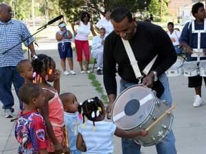 Bud johnson and kids gathered around drum