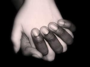 Black and white hands clasped together