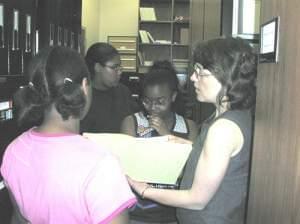 Youth Media Workshop students review documents at the Champaign County Historical Archives