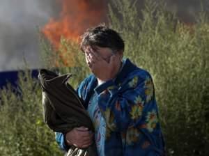 Woman cries near burning home in Slovyansk.