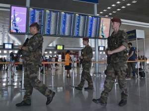 In Paris, soldiers patrol at Charles de Gaulle Airport last week. French airports have reportedly agreed to a new TSA policy requiring electronic devices to be powered up before they're allowed on U.S.-bound flights.
