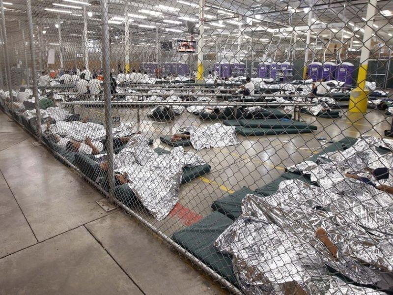 Detainees sleep and watch television in a holding cell where hundreds of mostly Central American immigrant children are being processed at a U.S. Customs facility in Nogales, Texas.