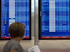 A woman passes by a departure board at Philadelphia International Airport showing that US Airways Flight 796 to Tel Aviv has been canceled Tuesday.