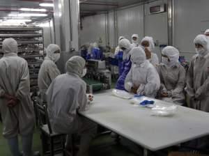 In this July 20, 2014 photo released by China's Xinhua News Agency, workers gather while they have nothing to do at the workshop of Shanghai Husi Food Co.