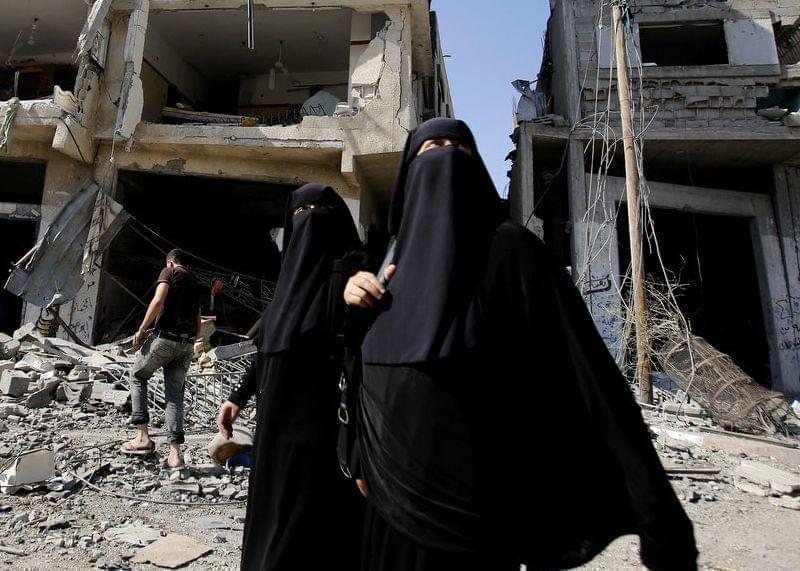 Palestinian women walk in Gaza City's Shijaiyah neighborhood