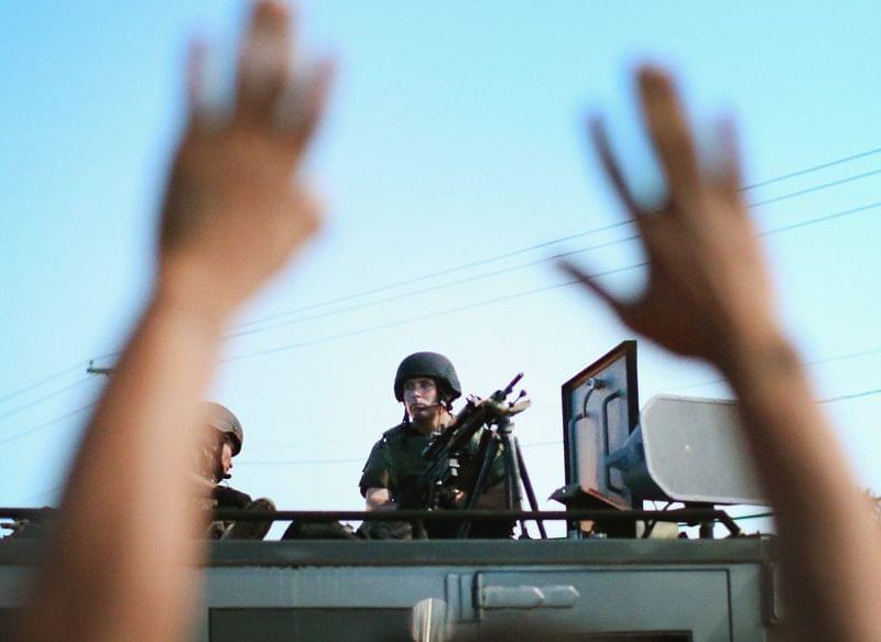 Police stand watch over protesters in Ferguson, Mo. on Aug. 13