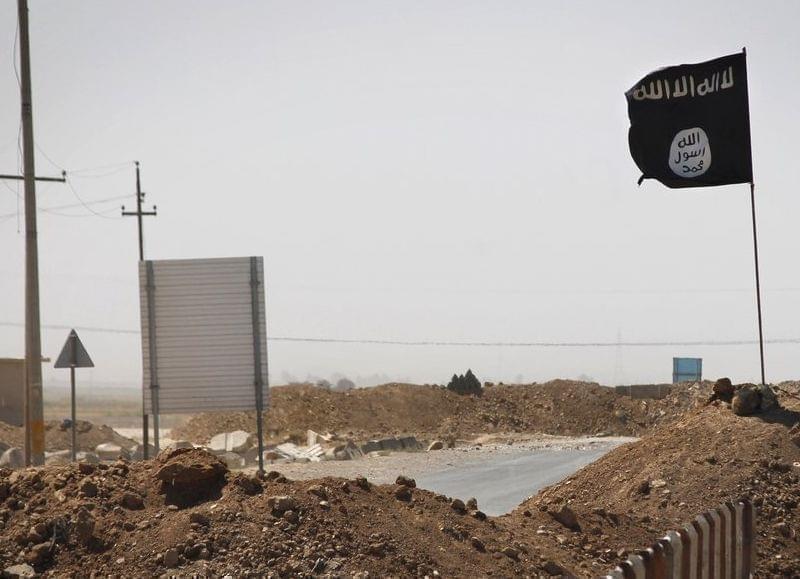 A flag of the Islamic State is seen on the other side of a barge in Iraq.