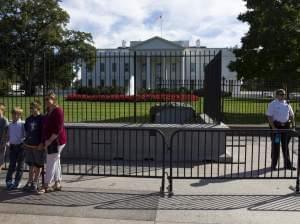 A Secret Service officer stands near tourists outside the White House Monday.