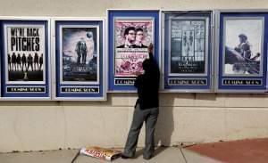 A poster for "The Interview" is taken removed from a display case at a Carmike Theater in Atlanta.