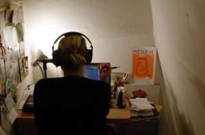 A woman recording audio in a small room