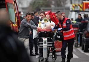 An injured person is transported to an ambulance after a shooting at a French satirical newspaper 