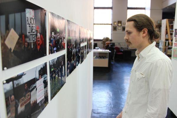 Travis Hocutt curator for the Black Lives Matter gallery at the Independent Media Center looks at the images in the exhibit