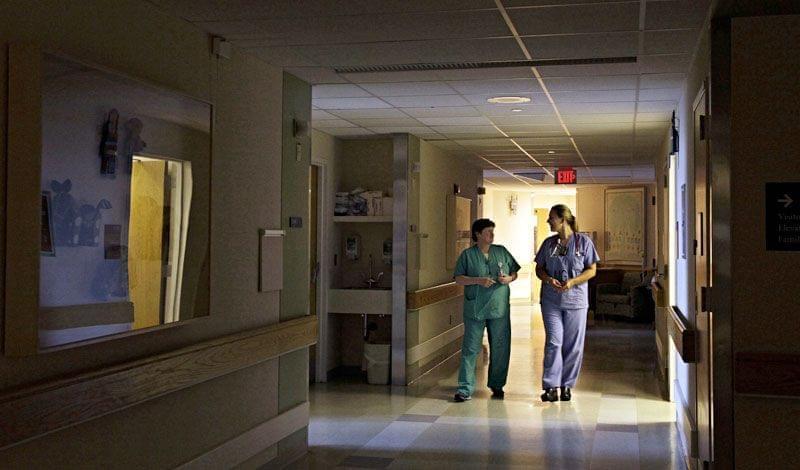 Two health care workers walking in a hospital hallway