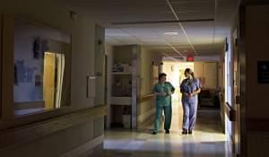 Two health care workers walking in a hospital hallway