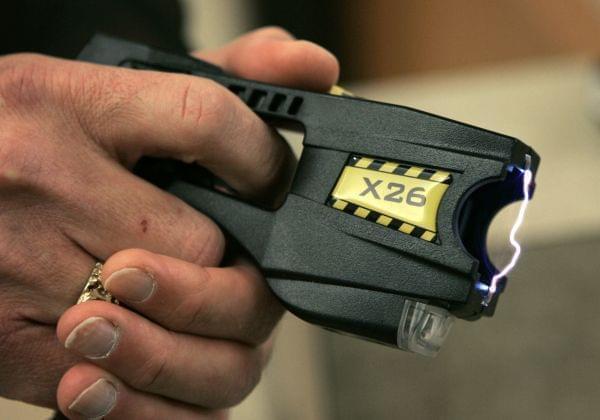 A Taser X26 is shown on display.