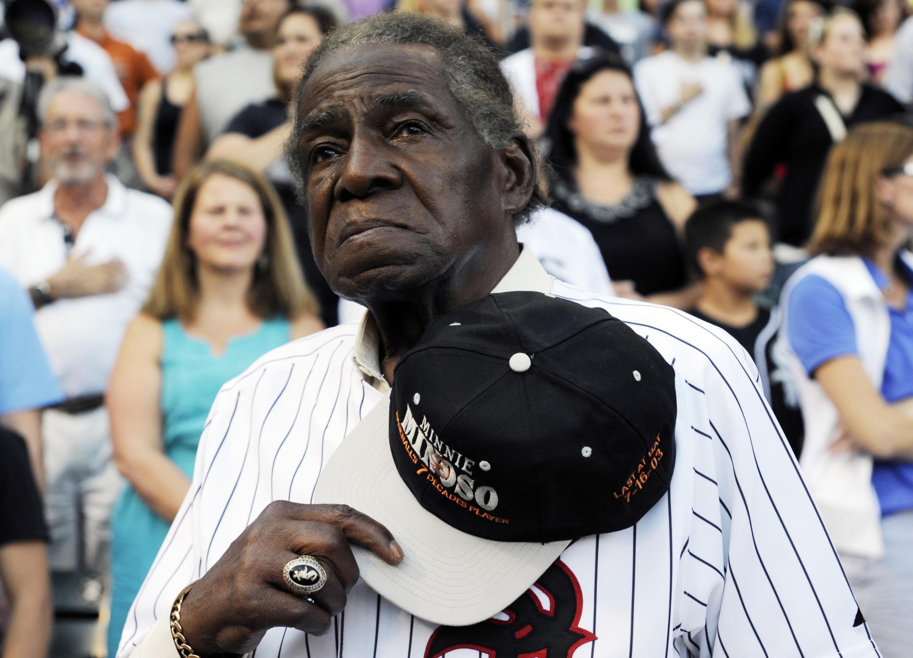 Former Negro Leaguer and Chicago White Sox player Minnie Minoso stands during the national anthem before a baseball game between the Chicago White Sox and the Texas Rangers in August 2013.