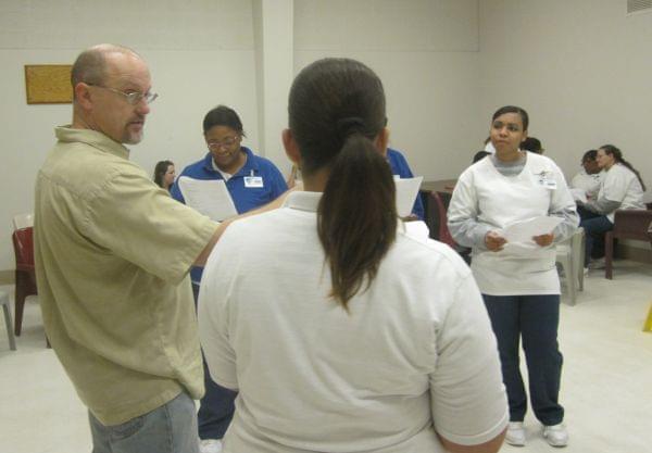 Millikin University Professor Alex Miller instructs women from the Decatur Correctional Center in a scene from Macbeth.