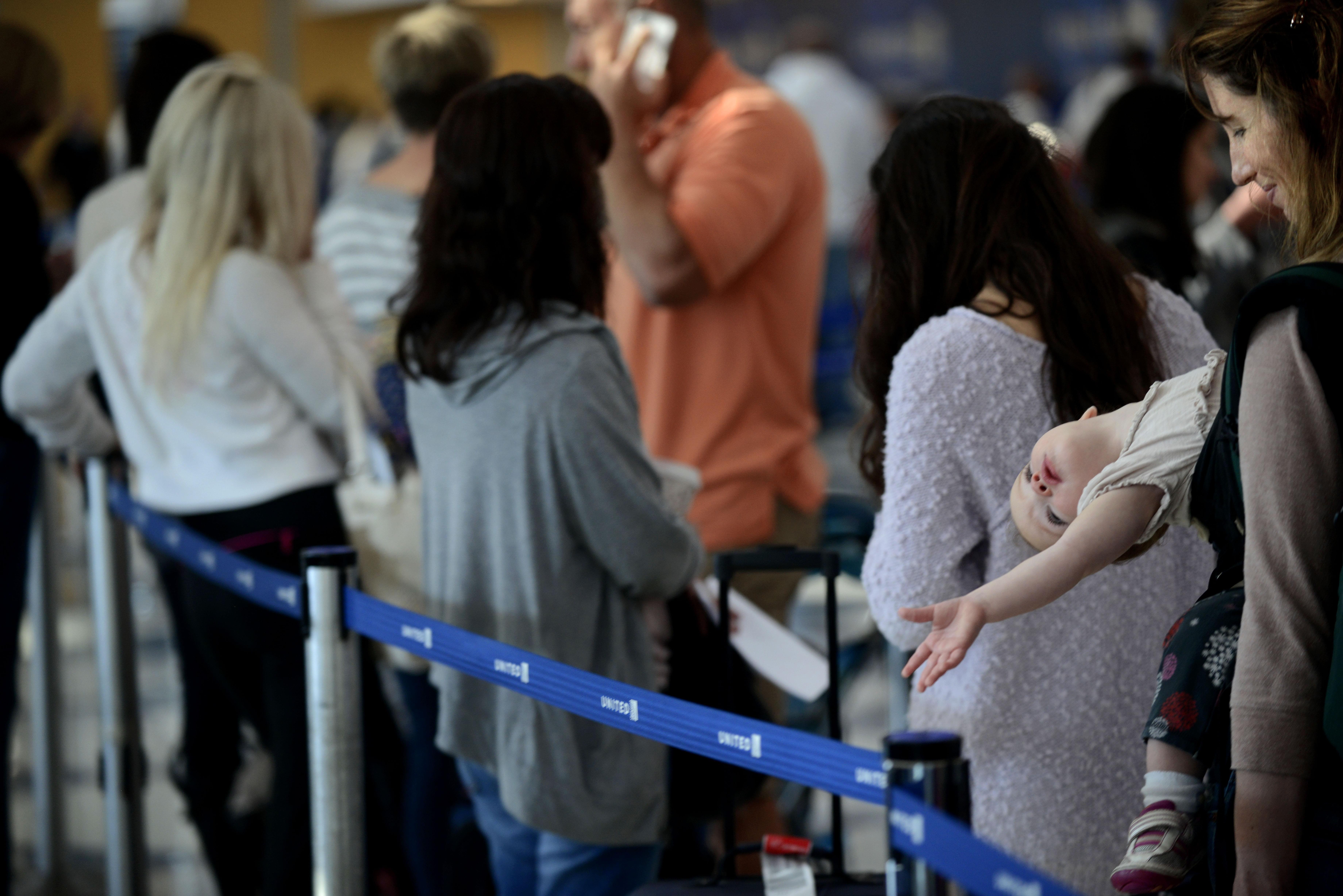 Travelers wait in line after several delays at O'Hare International Airport in Chicago.