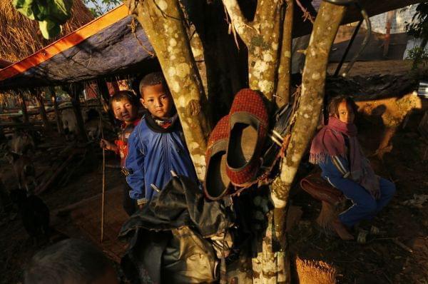 Children peer out of makeshift shelter in destroyed village of Paslang near the epicenter of Saturday's massive earthquake in the Gorkha District of Nepal, Tuesday, April 28, 2015. Military operations continue Tuesday to reach the isolated areas