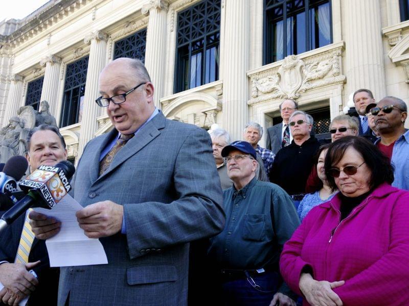 Illinois AFL-CIO President Michael Carrigan is joined by state workers and retirees outside the Illinois Supreme Court in Springfield, Ill., Wednesday, March 11, 2015, as he addresses the media following oral arguments in a lawsuit over a state pensi