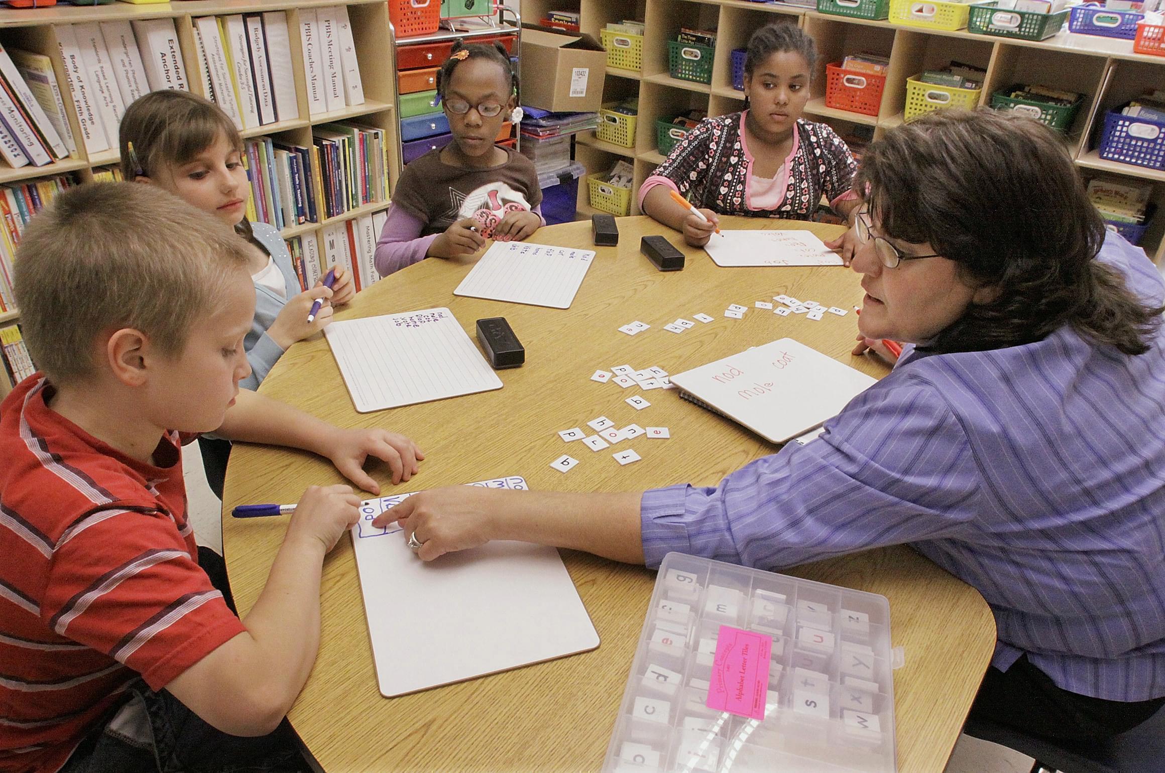 Jackie Peters, right, works with her third grade students at Ridgely Elementary School in Springfield, Ill. Over two years, Illinois will get about $1 billion in federal grants such as special education and Title I, which provides grants for low-inco