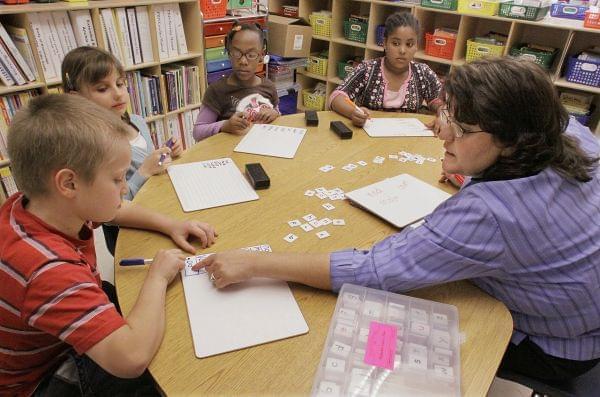 Jackie Peters, right, works with her third grade students at Ridgely Elementary School in Springfield, Ill. Over two years, Illinois will get about $1 billion in federal grants such as special education and Title I, which provides grants for low-inco