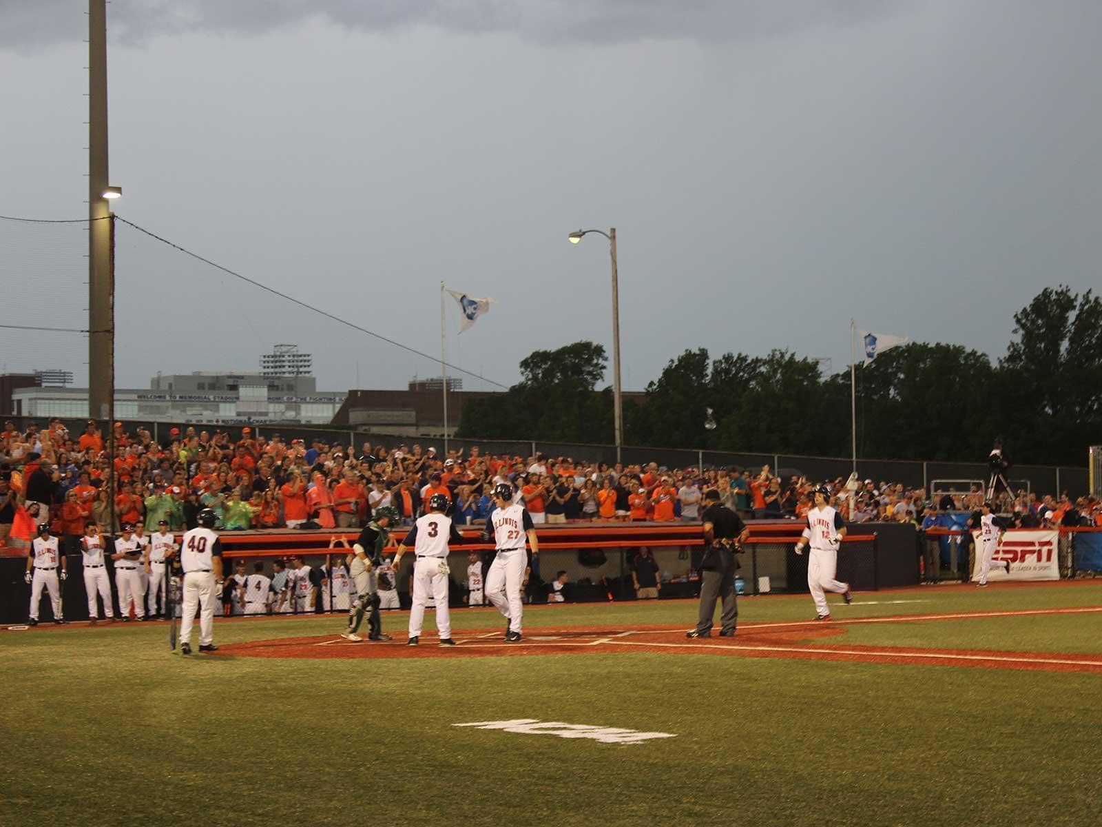 Illinois players wait to congratulate first baseman David Kerian after his three-run homer against Ohio Friday. Illinois won the game, 10-3.