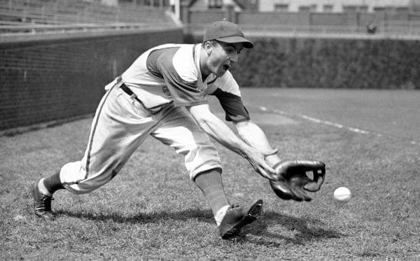 In this April 29, 1942, file photo, Chicago Cubs' Lennie Merullo fields a baseball in Chicago. The oldest former member of the Cubs and the last living person to play for them in the World Series, he died Saturday at age 98. 