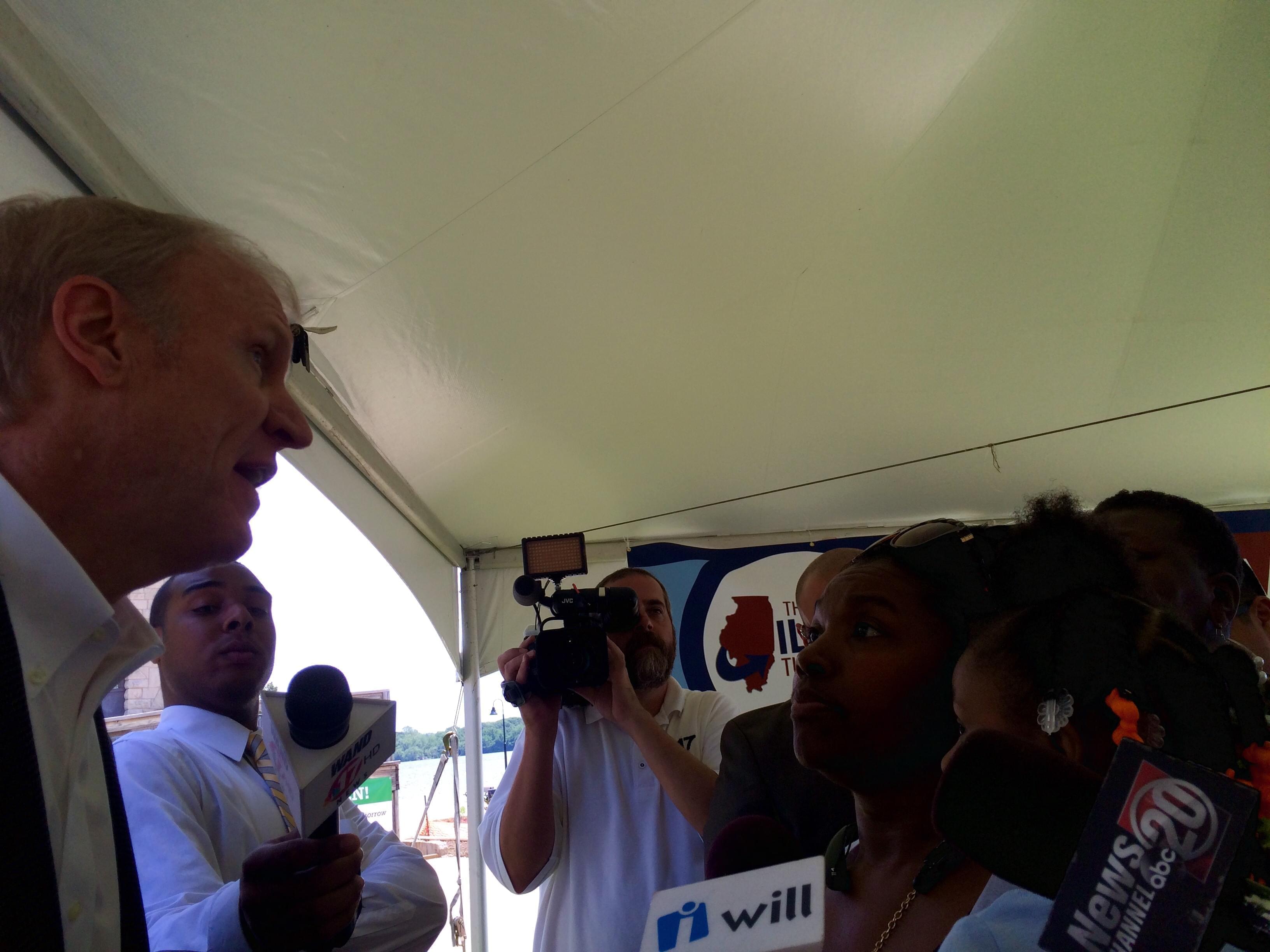 Gov. Bruce Rauner and Decatur resident Annie Yarbary chat Wednesday as media looks on.