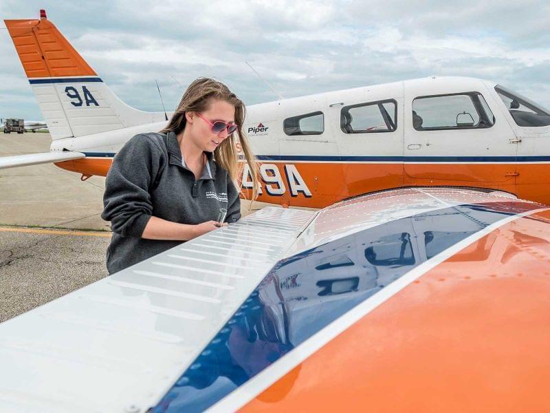Bobbie Britz, who earned her flight instructor from the Institute of Aviation in 2014, goes through pre-flight equipment checks Tuesday. 