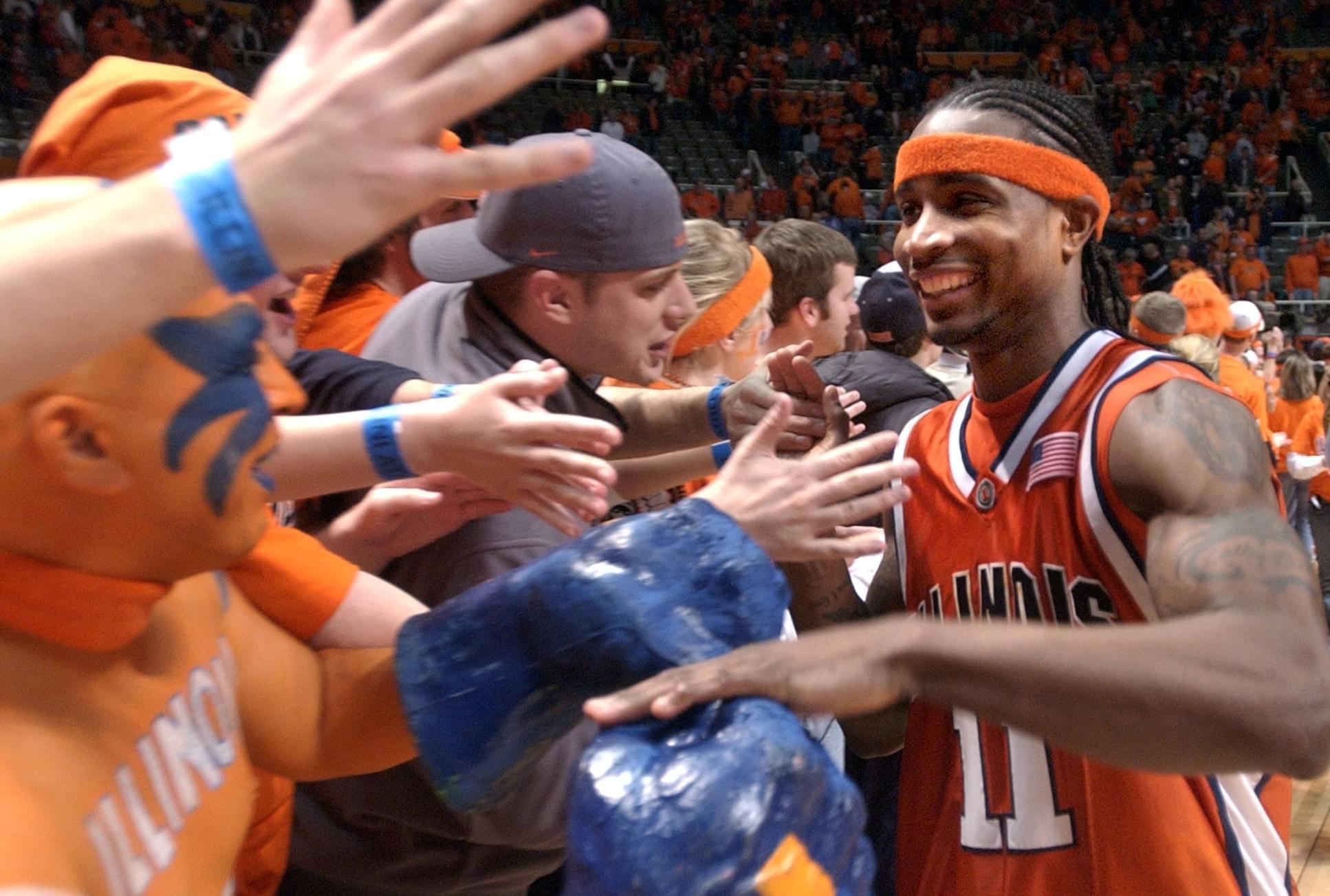 Illinois' Dee Brown slaps hands with members of the Orange Krush after Illinois beat Iowa 71-59 at the Assembly Hall in Champaign on Saturday Feb. 25, 2006. 