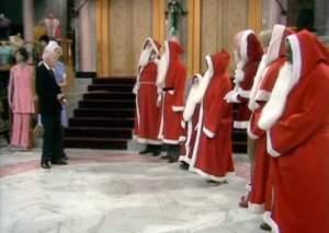 Young Mr. Grace inspects a line of people dressed as Santa.