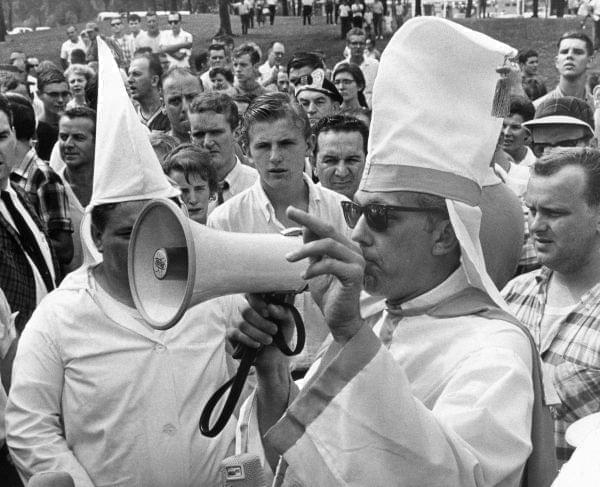Man clad in Ku Klux Klan type robes uses bullhorn to address crowd in Marquette Park, Chicago on August 21, 1966 following rally staged by American Nazi Party. He was arrested for speaking without a permit and identified himself as Evan Lewis, 34, of