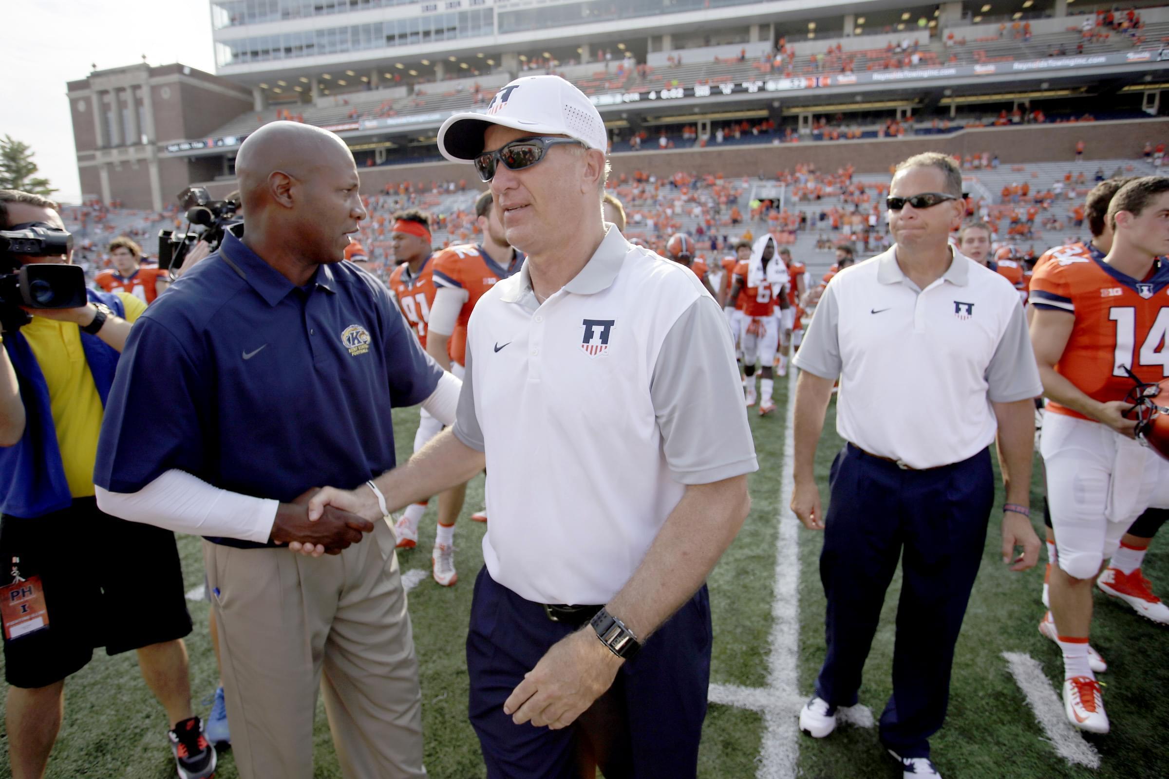 Illinois interim head coach Bill Cubit, right, shakes hands with Kent State head coach Paul Haynes at the end of Illinois' 52-3 victory Saturday in Champaign