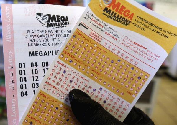 In this Dec. 12, 2013. file photo, a customer holds a Mega Millions lottery ticket at a convenience store in Chicago. State officials announced Friday, Aug. 15, 2014, that Illinois will end its contract with the private vendor that operates the $2 bi