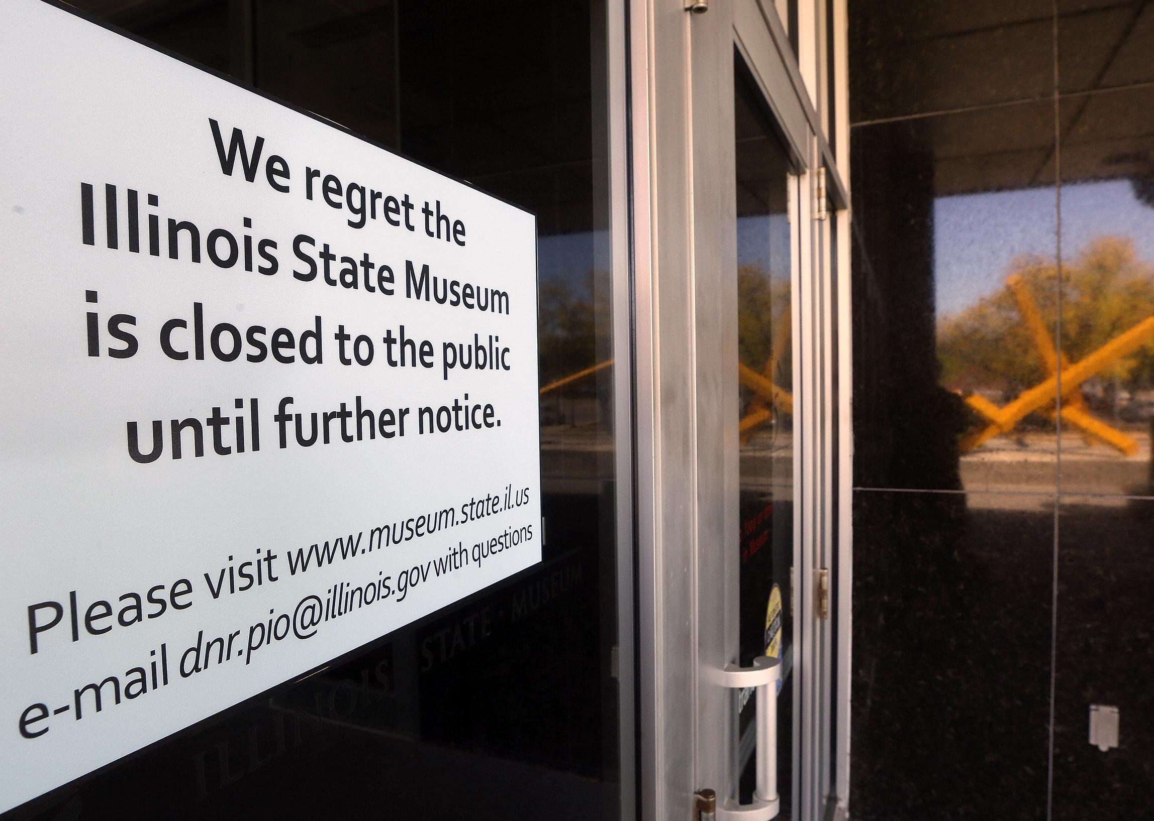 The reflection of a sculpture highlights the closing notice on the front door of the Illinois State Museum, Thursday, Oct. 1, 2015, in Springfield.